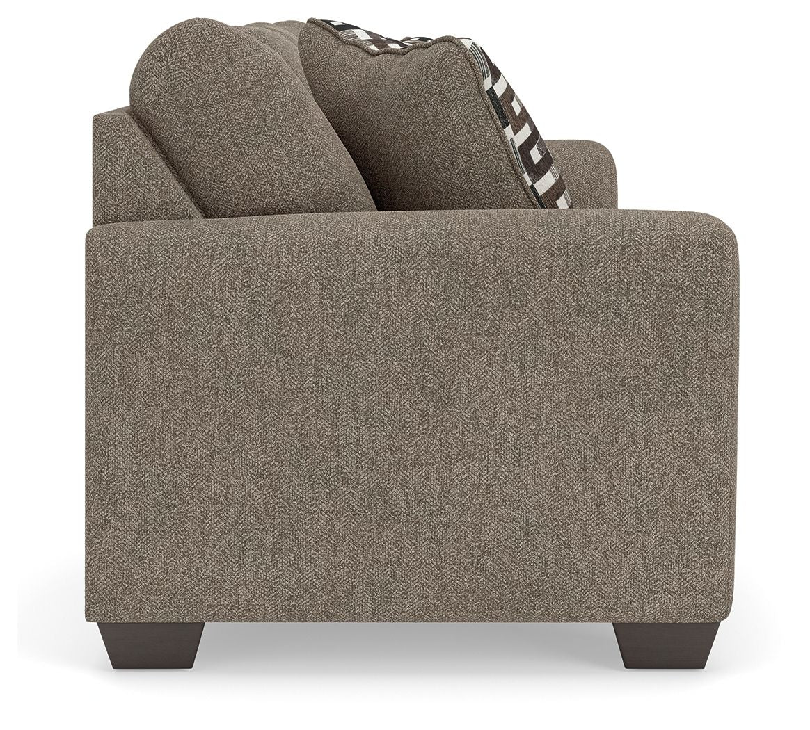 Beige upholstered armchair with textured fabric and black-and-white geometric pillow