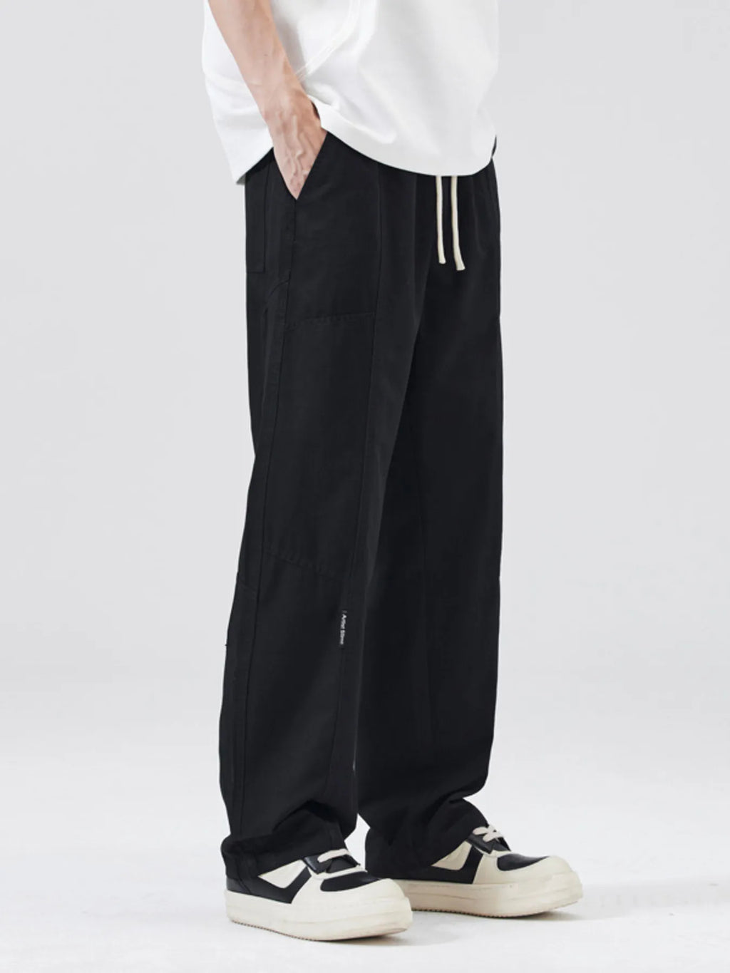 Black wide-leg drawstring pants with vertical side pockets