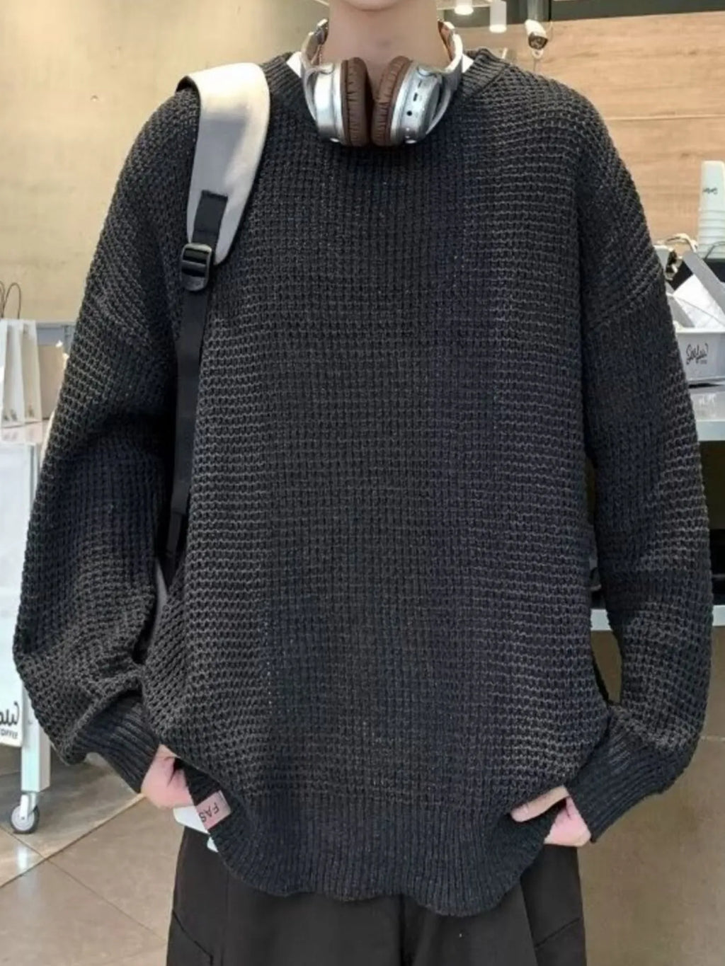 Black waffle-knit crewneck sweater, long sleeves, relaxed fit, ribbed cuffs and hem