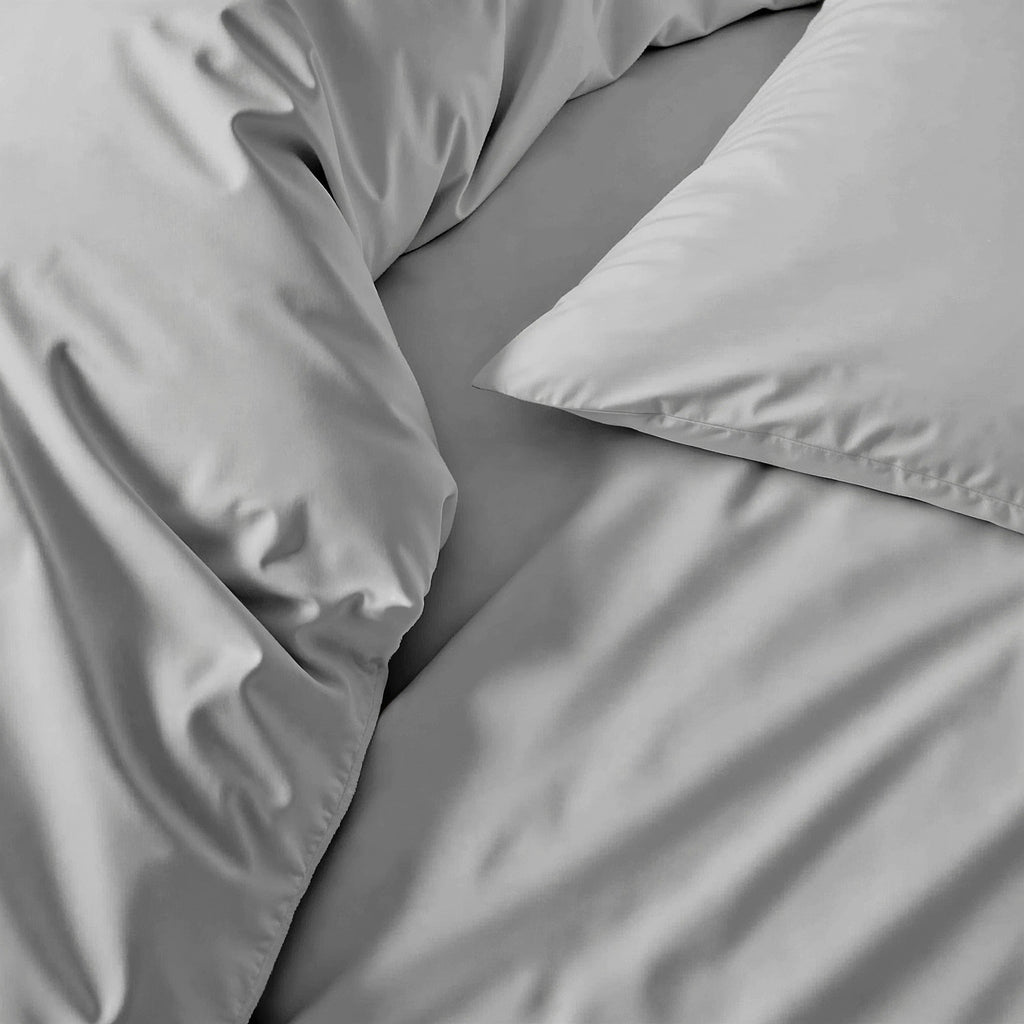 Gray sateen sheet and pillowcase close-up, smooth fabric with subtle sheen