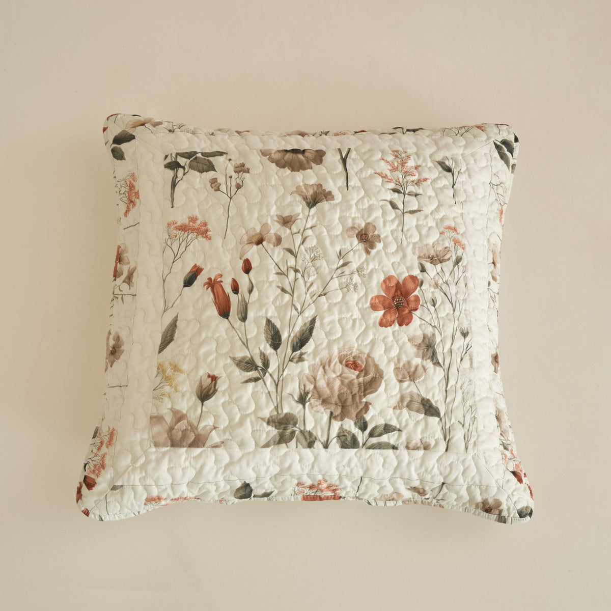 Floral throw pillow in off-white with botanical print and visible quilted channels.