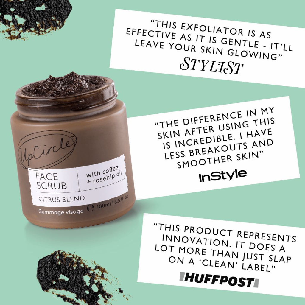 Face scrub jar with dark brown paste on top, plus small piles of exfoliating scrub