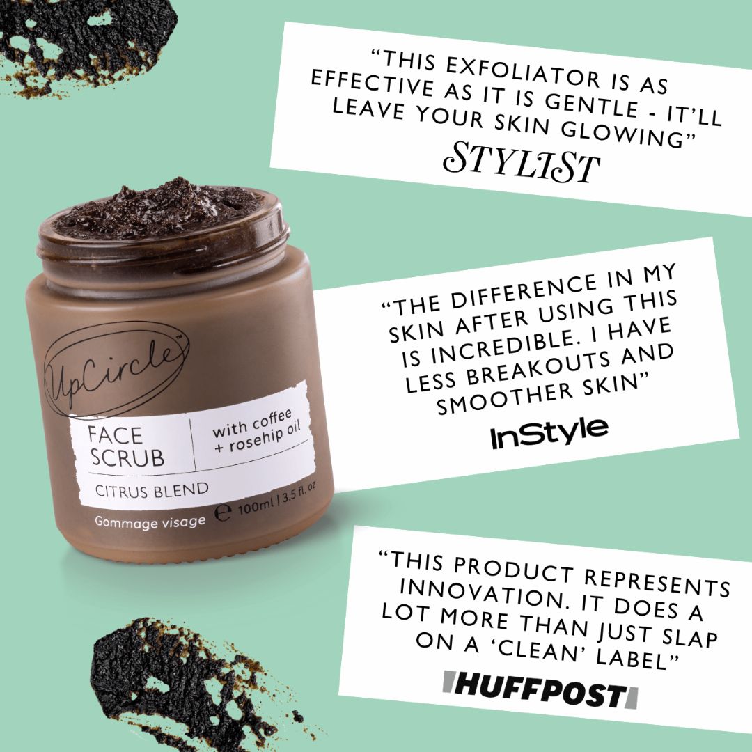Face scrub jar with dark brown paste on top, plus small piles of exfoliating scrub