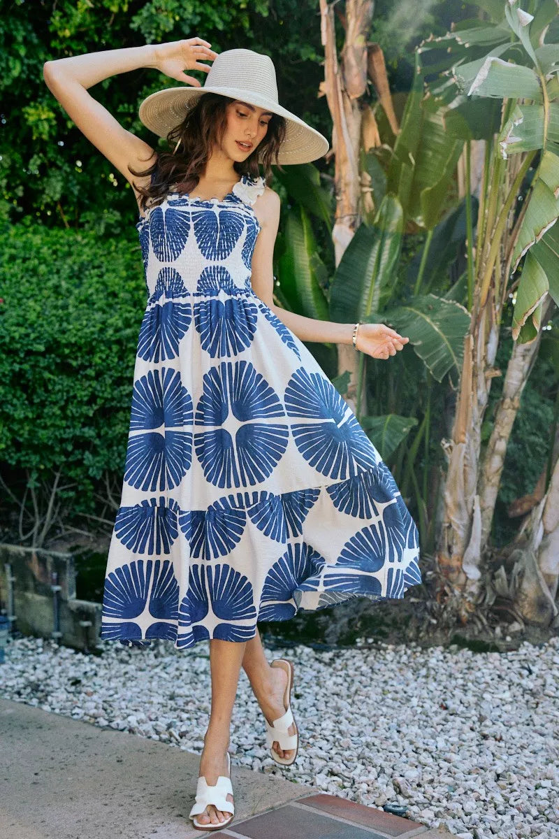 Side view of navy and white abstract print tiered midi dress with smocked bodice