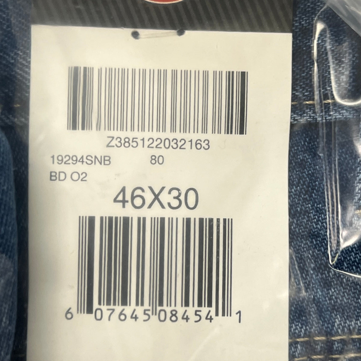 Barcode size tag on indigo blue denim jeans, marked 46X30.