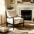 Upholstered accent chair with cream cushions, black beaded wood frame, and padded arms