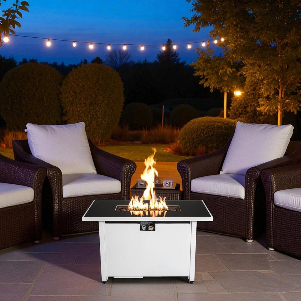White rectangular fire pit table centered in outdoor seating with visible flames