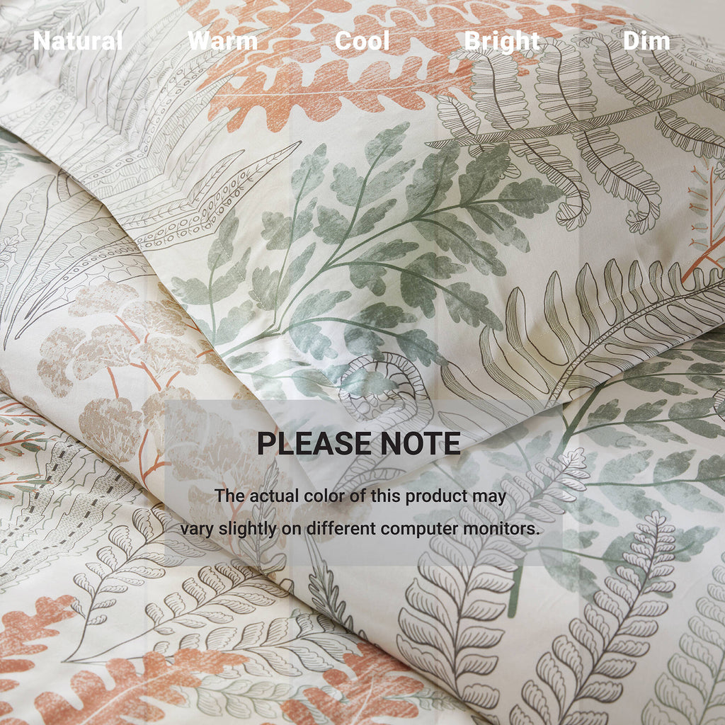 Close-up duvet cover fabric with botanical leaf print, white background with terracotta and sage