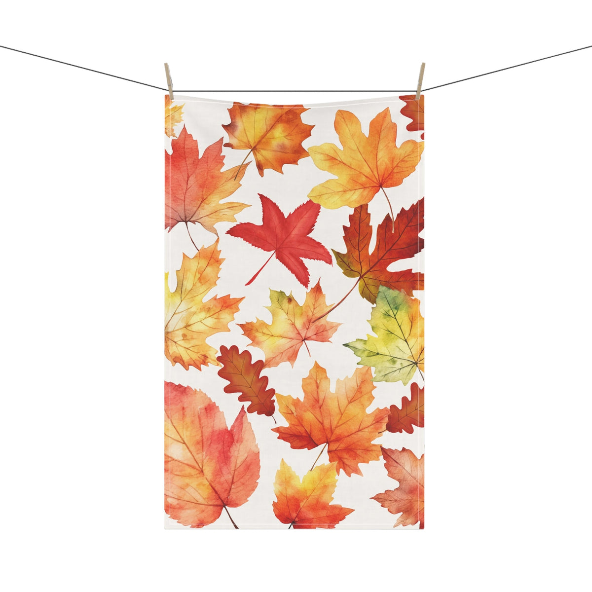 Autumn leaf tea towel clipped on a line, multicolor maple leaves on white fabric