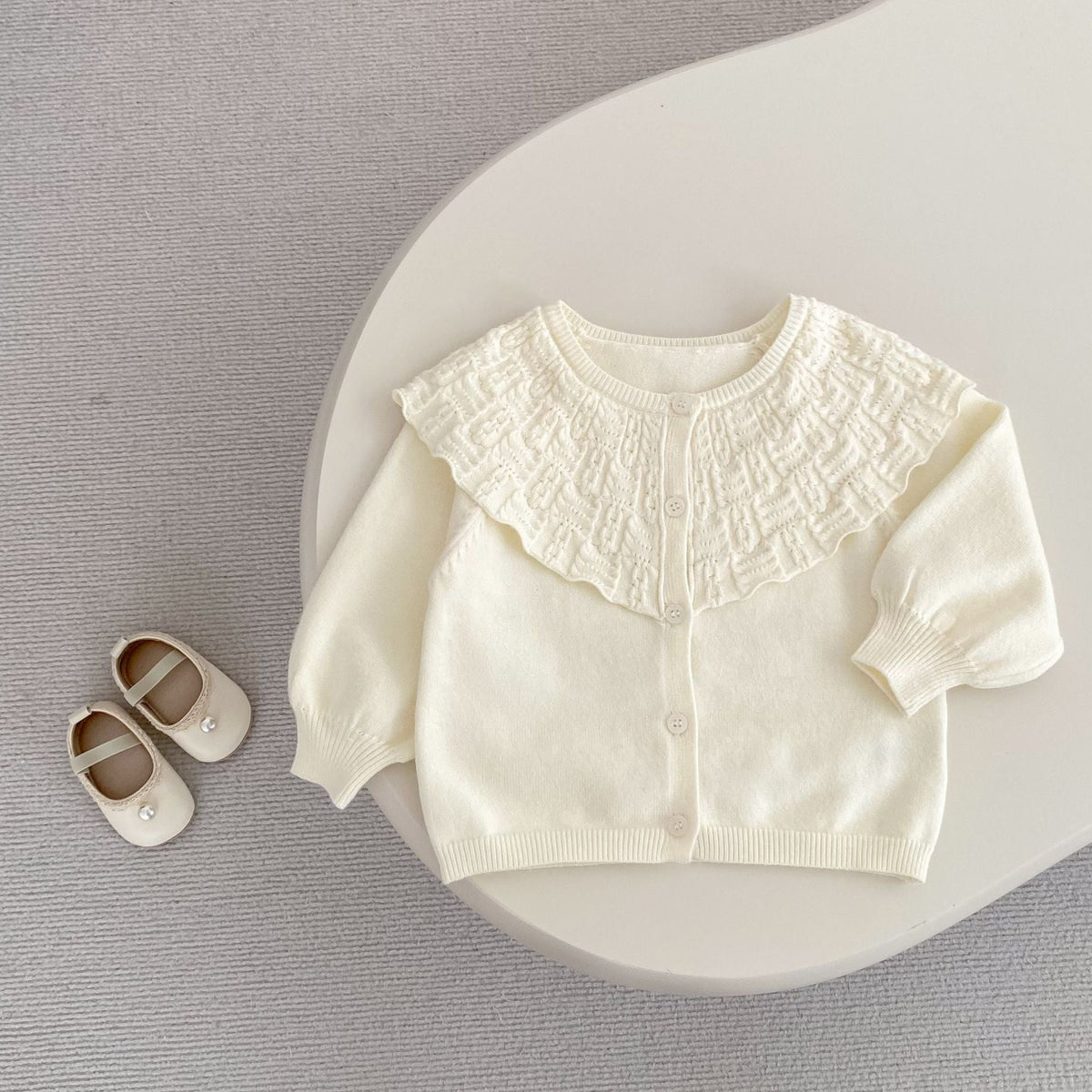 Cream baby knitted cardigan coat with large ruffled lapel and button-front