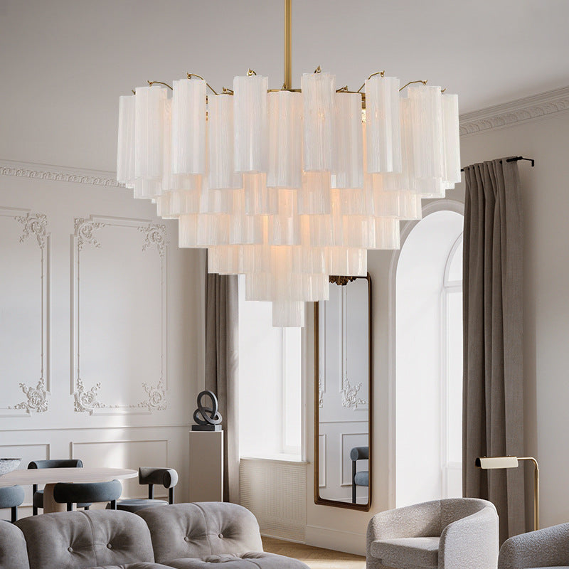 Tiered frosted glass tube chandelier with white shades on a gold stem