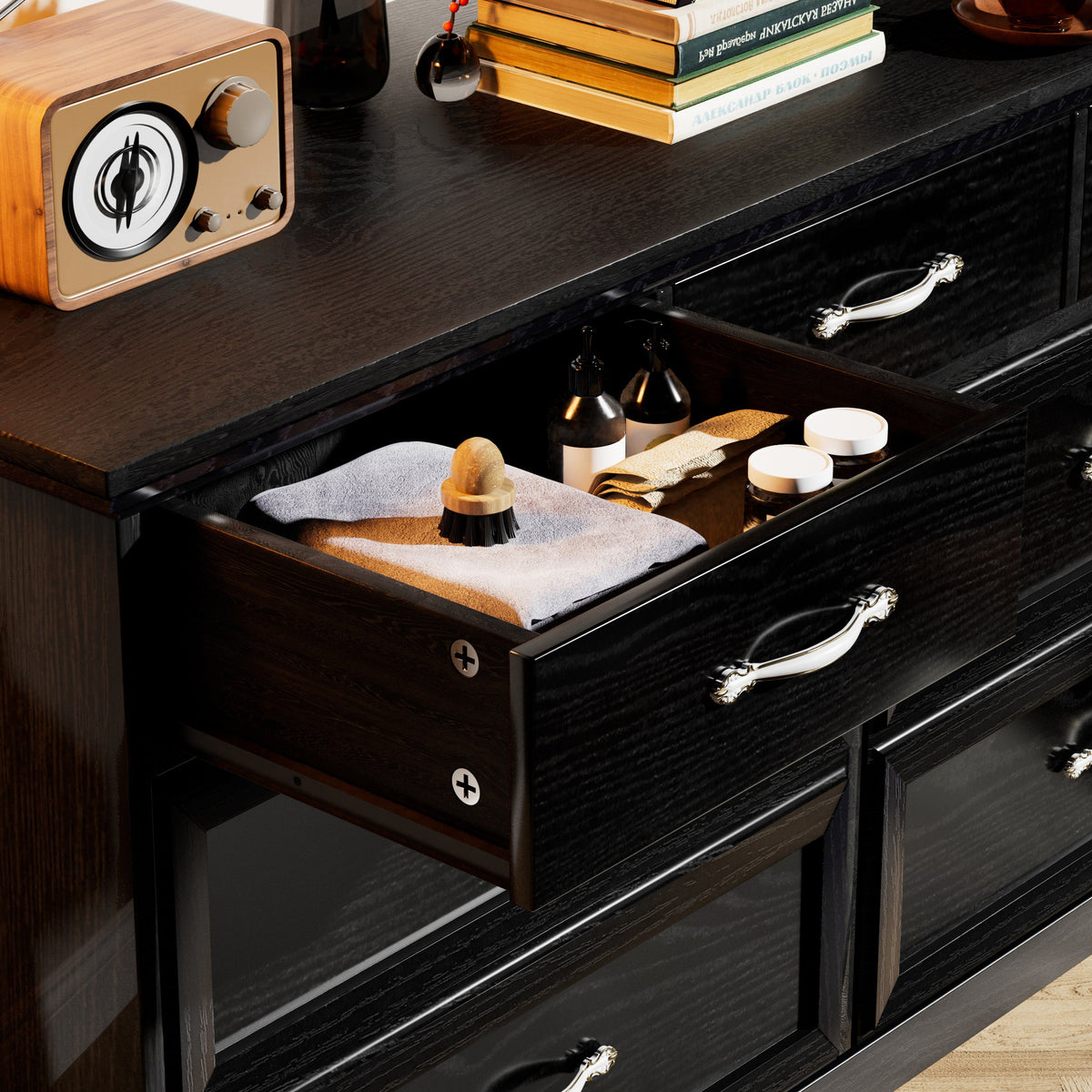 Black dresser chest with partially open drawers and chrome bar pull handles