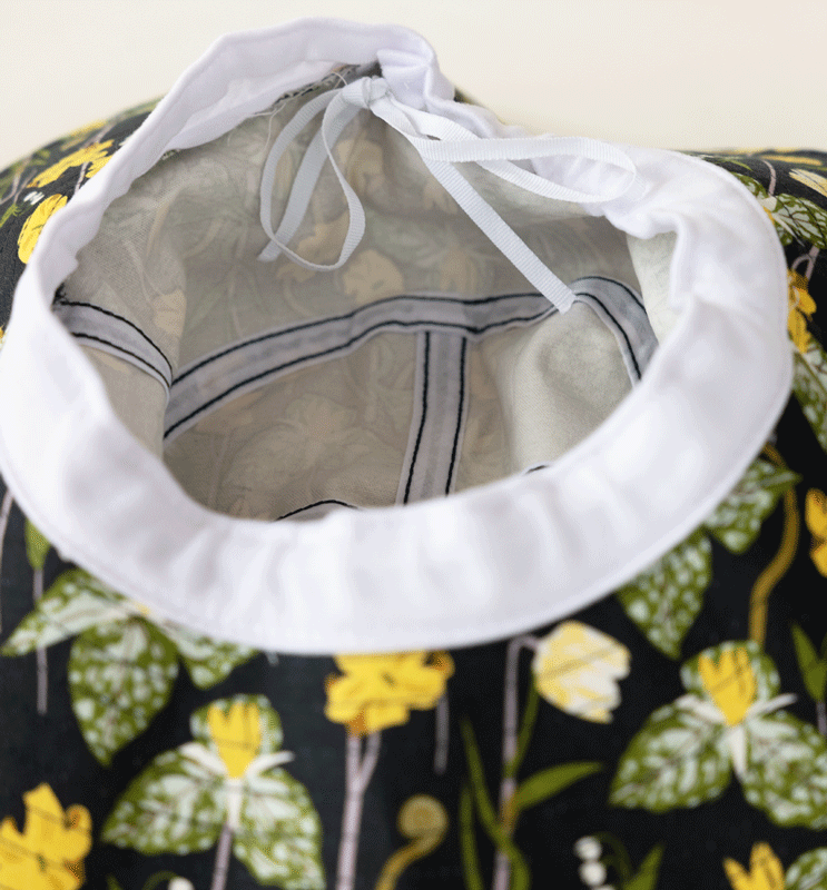 Cotton bucket hat interior with white lining and adjustable drawstring ties.