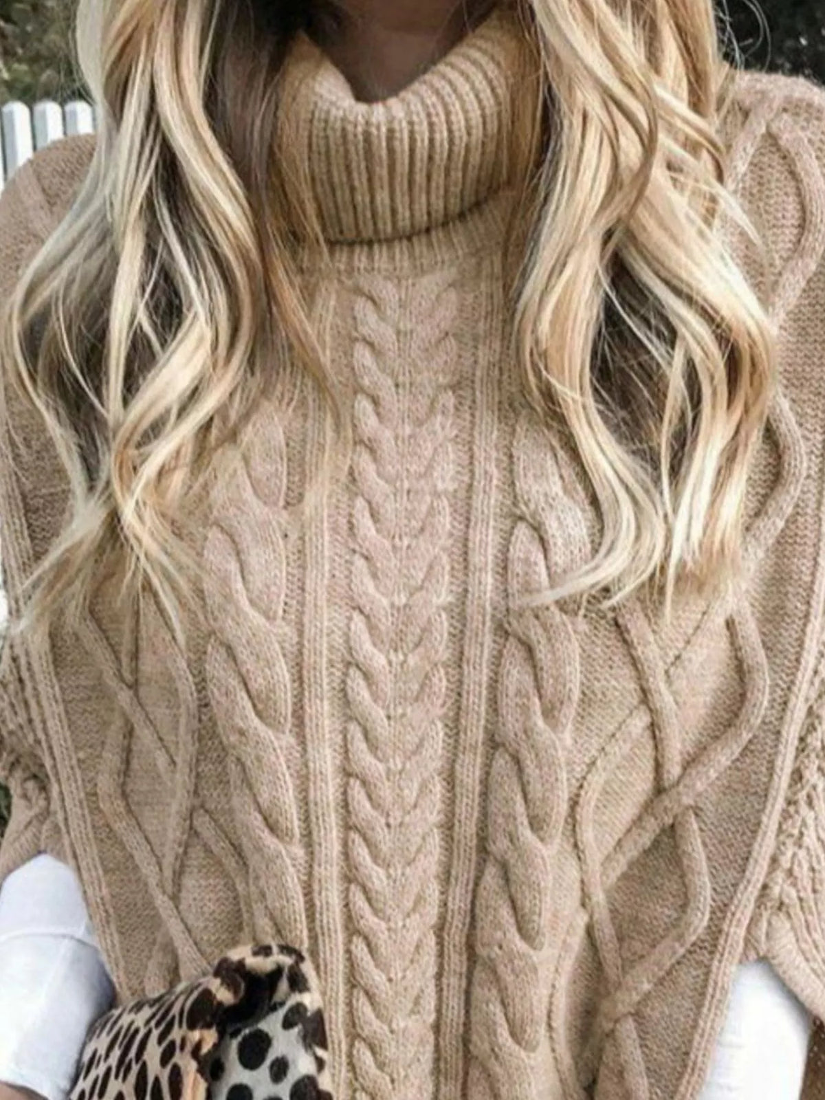 Tan cable-knit turtleneck poncho cover-up close-up with braided cable pattern