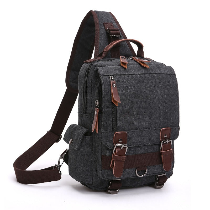 Charcoal canvas backpack with side handle, front flap pocket, and adjustable shoulder strap