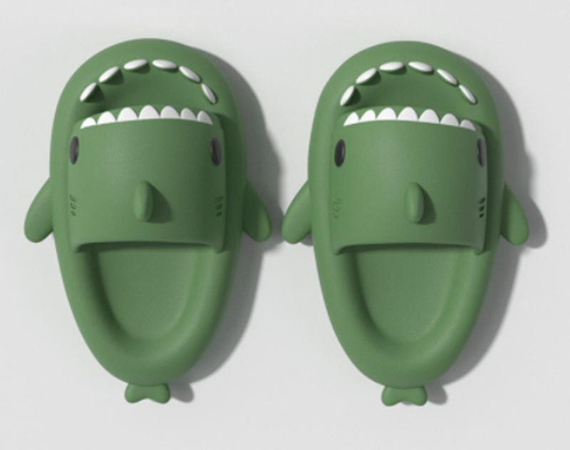 Pair of green shark slide sandals, top view with open toe and white teeth trim