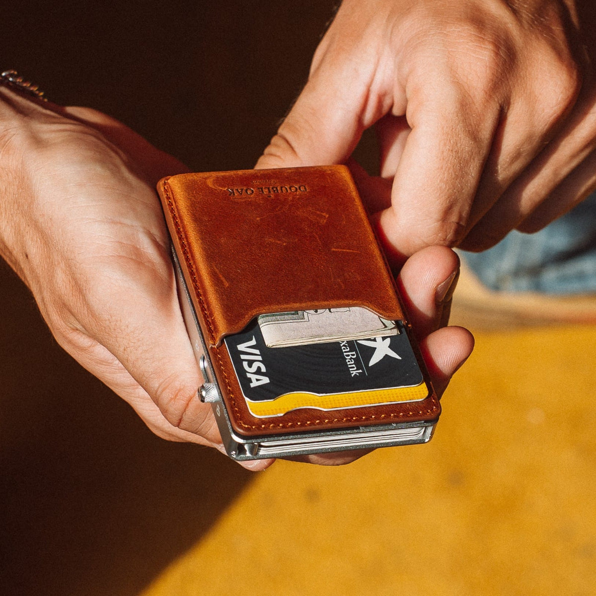 Brown leather mod wallet with card and metal clip detail, close-up in hand
