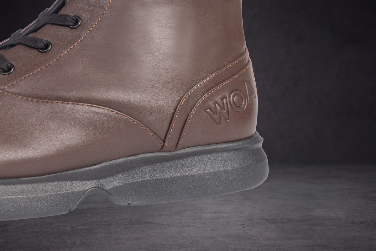 WOA taupe boot side view with WOA logo and thick gray rubber sole