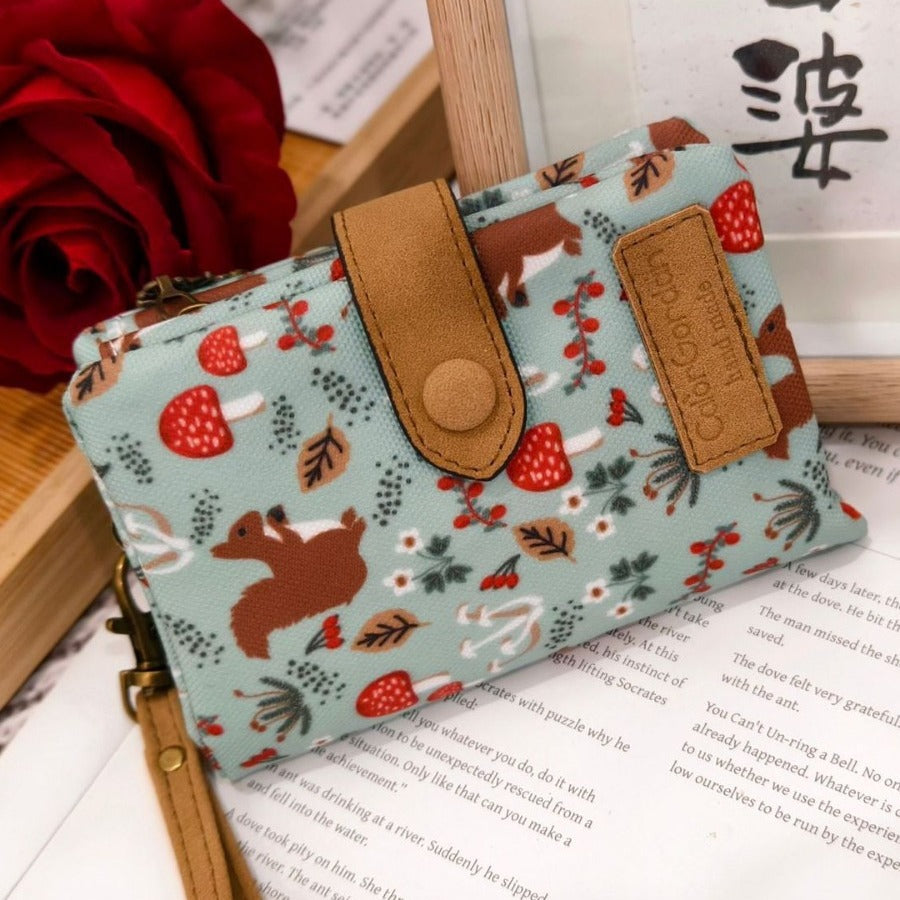 Printed tri-fold wallet with snap button and strap, light blue woodland animal pattern