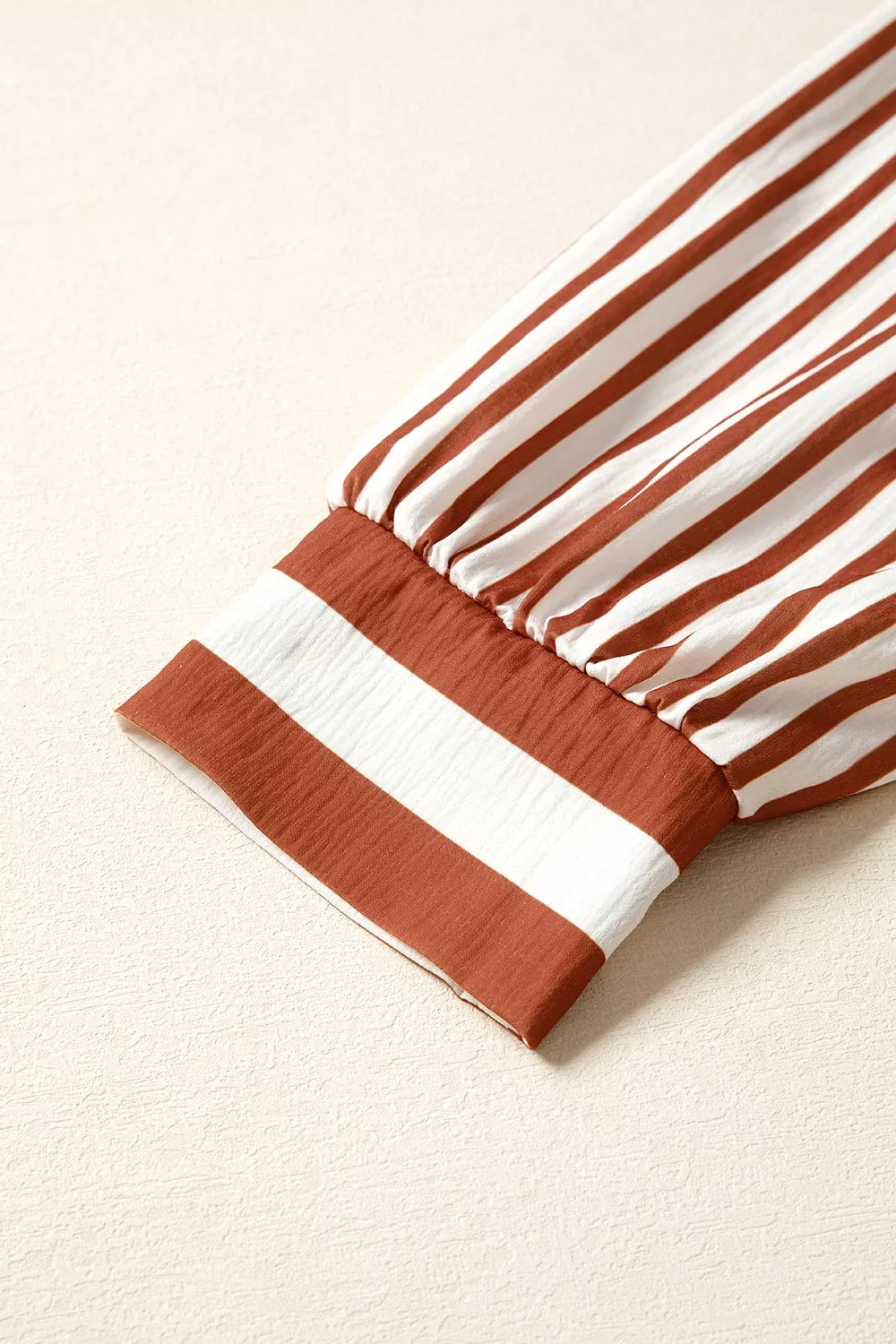 Striped long-sleeve blouse cuff with brown ruffle band at sleeve hem