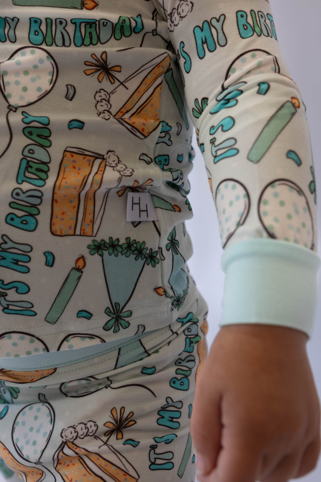 Kids light blue pajama set close-up with "MY BIRTHDAY" text, cake and balloon print