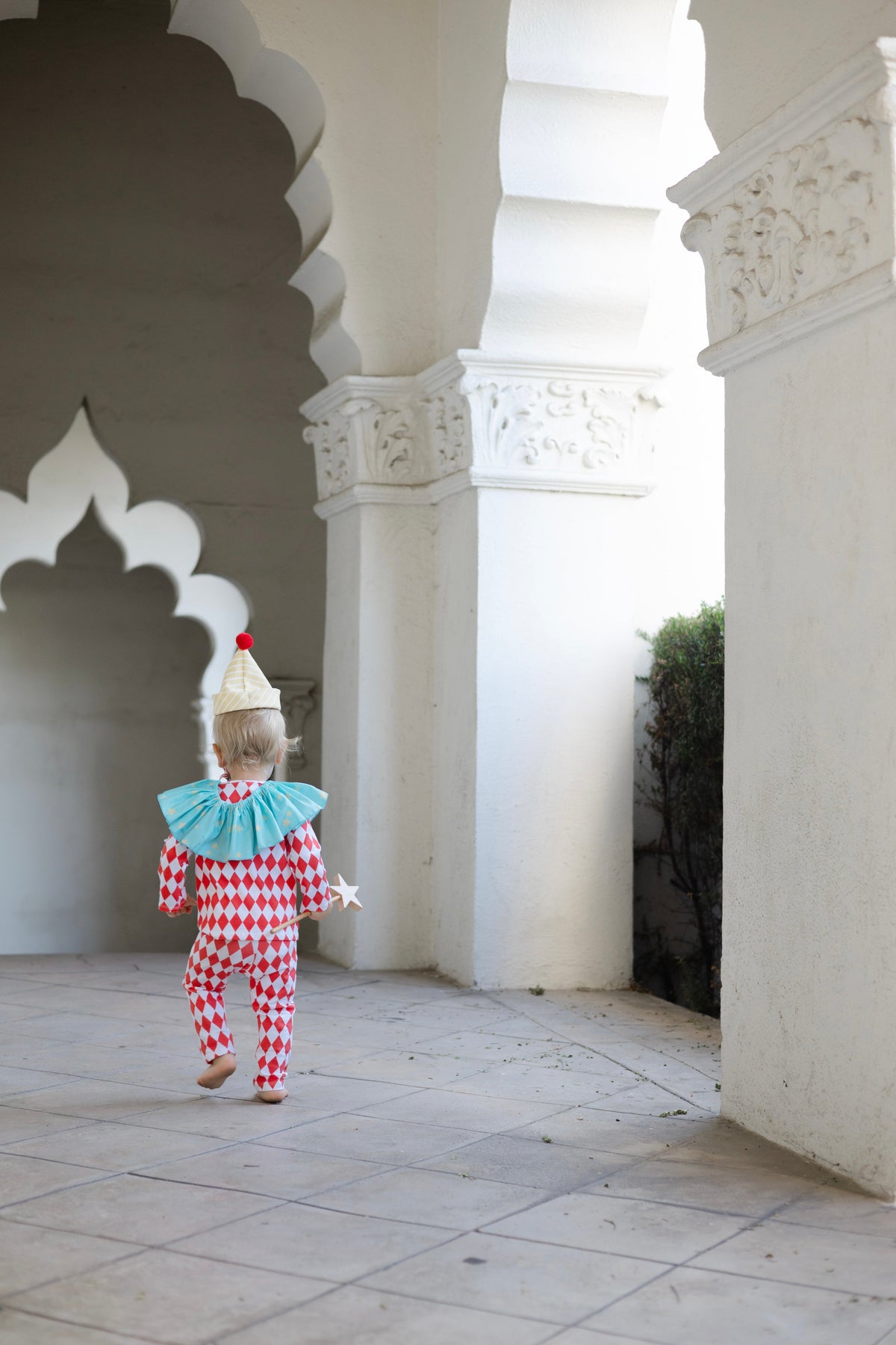 Kids clown costume from behind: red-and-white diamond jumpsuit, light blue ruffled collar, striped hat
