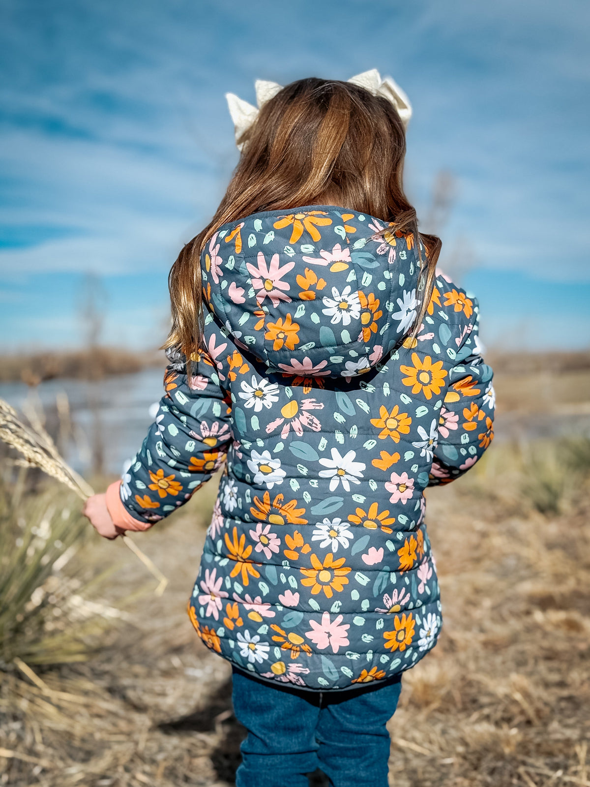 Kids lightweight puffy jacket, back view with teal floral pattern and hood