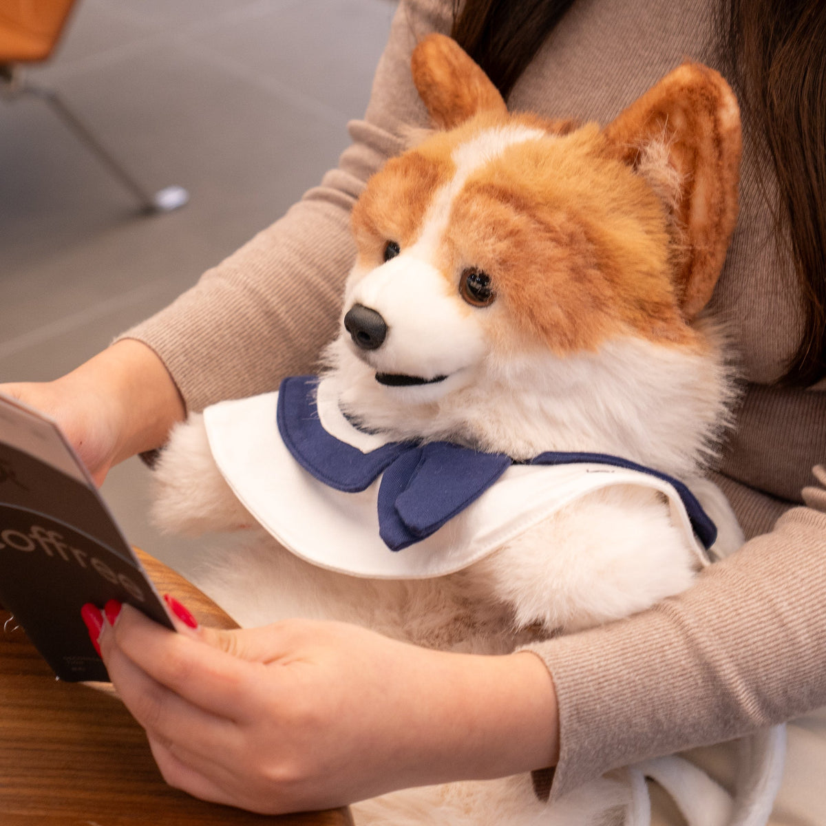 Plush corgi backpack close-up with navy bow collar, white belly, and side profile