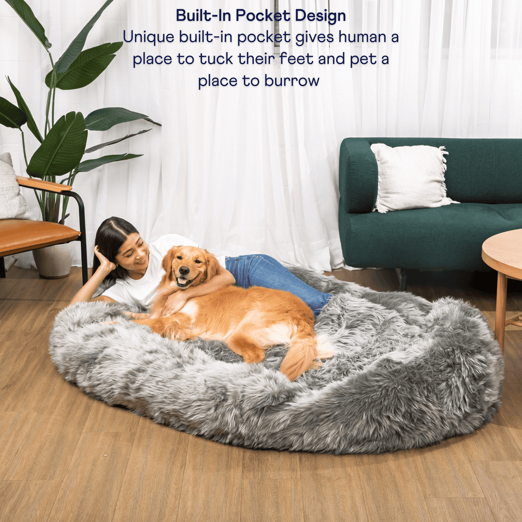 Charcoal grey round faux fur dog bed with plush interior as pets lounge