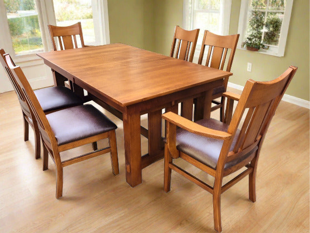 Rectangular wooden dining table with multiple chairs, dark brown upholstered seat pads.