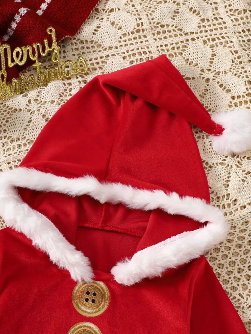 Children’s red Santa hooded one-piece with white fur trim and round wooden-style buttons