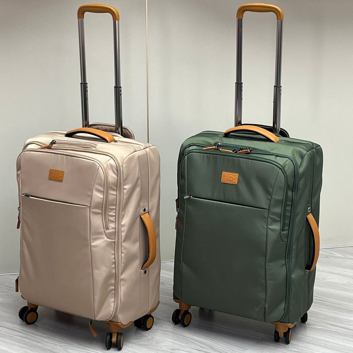 Pair of ultra-light wheeled trolley suitcases in cream and green, with telescoping handles