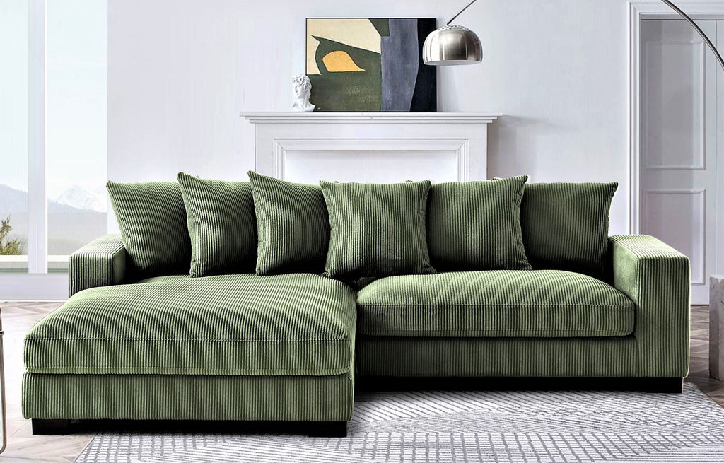 Green L-shaped sectional sofa with chaise, thick armrests and four accent pillows.
