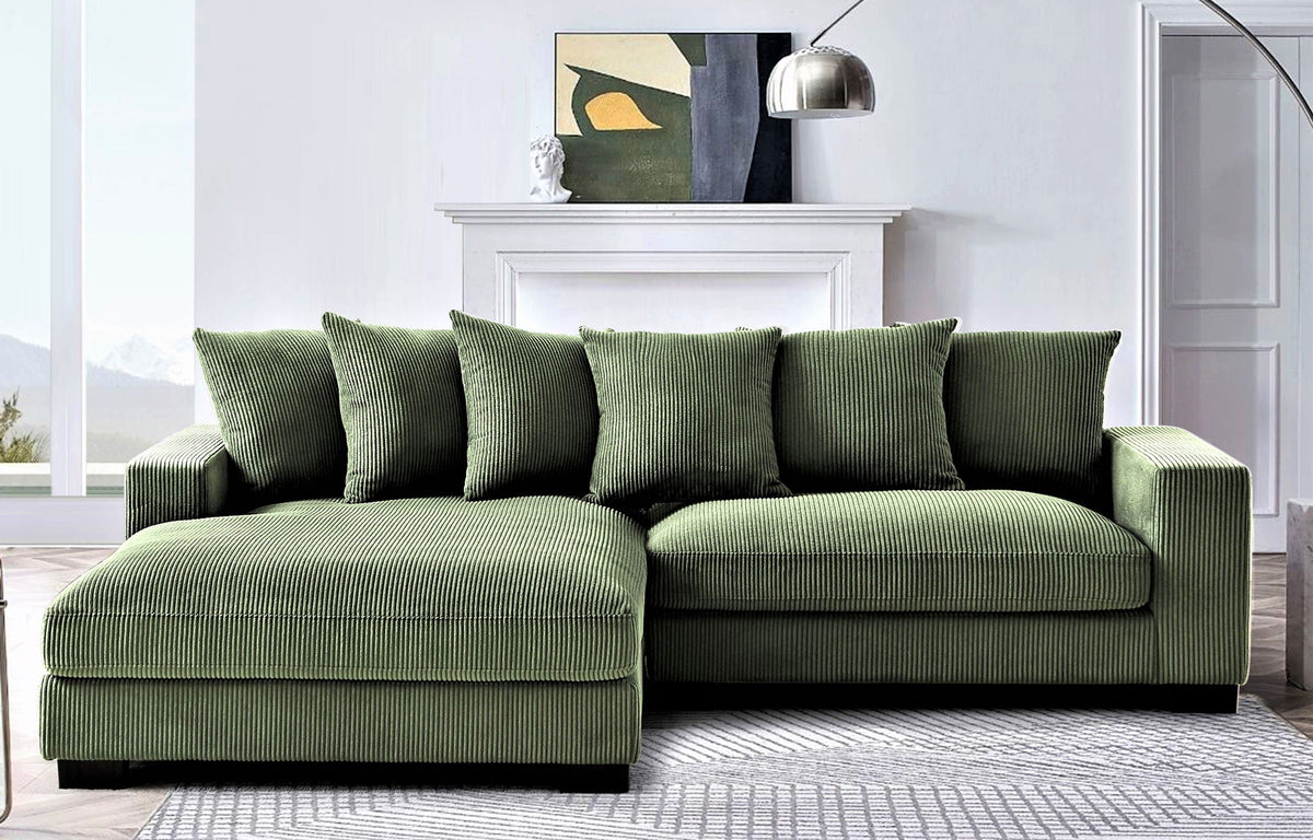 Green L-shaped sectional sofa with chaise, thick armrests and four accent pillows.