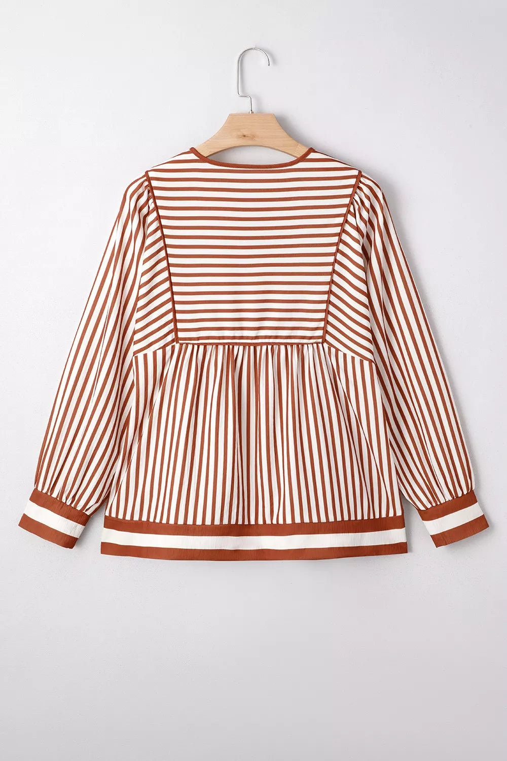 Striped babydoll long-sleeve blouse on hanger with gathered waist and cuff trim
