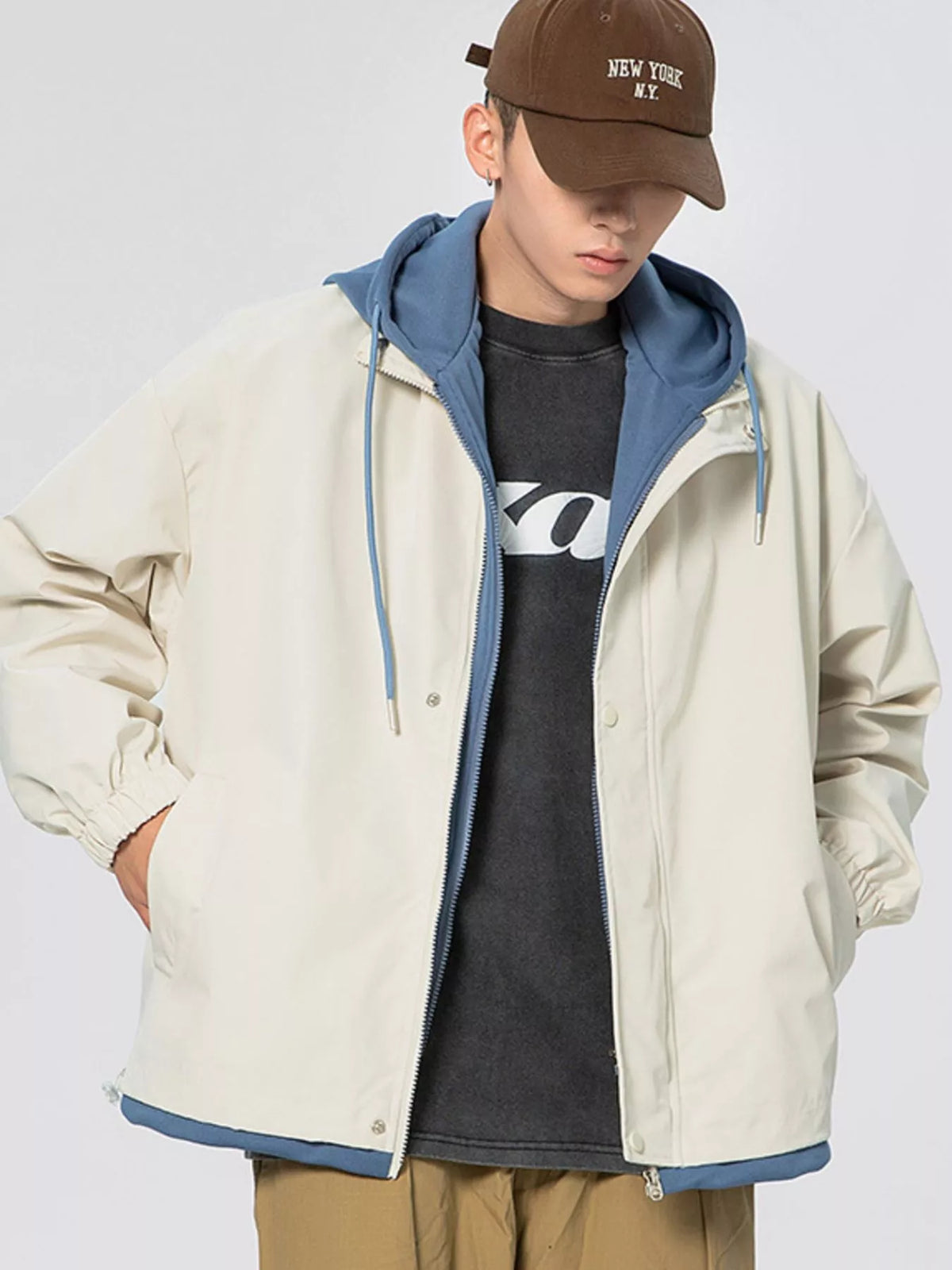 Light khaki windbreaker jacket with blue-lined hood and front zipper