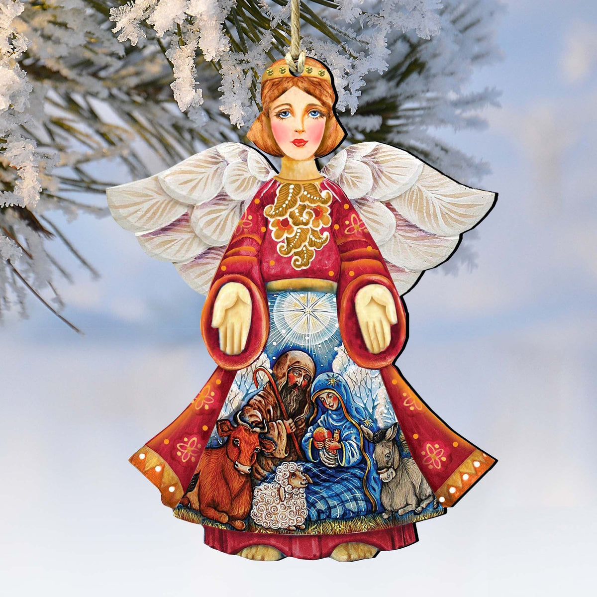 Nativity angel wooden ornament with red robe, white wings, and blue manger scene.