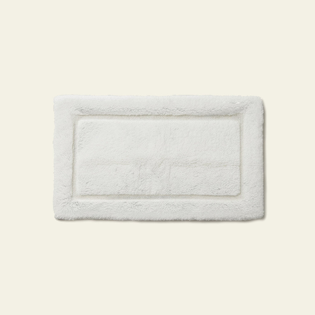 White rectangular bath mat with textured plush surface