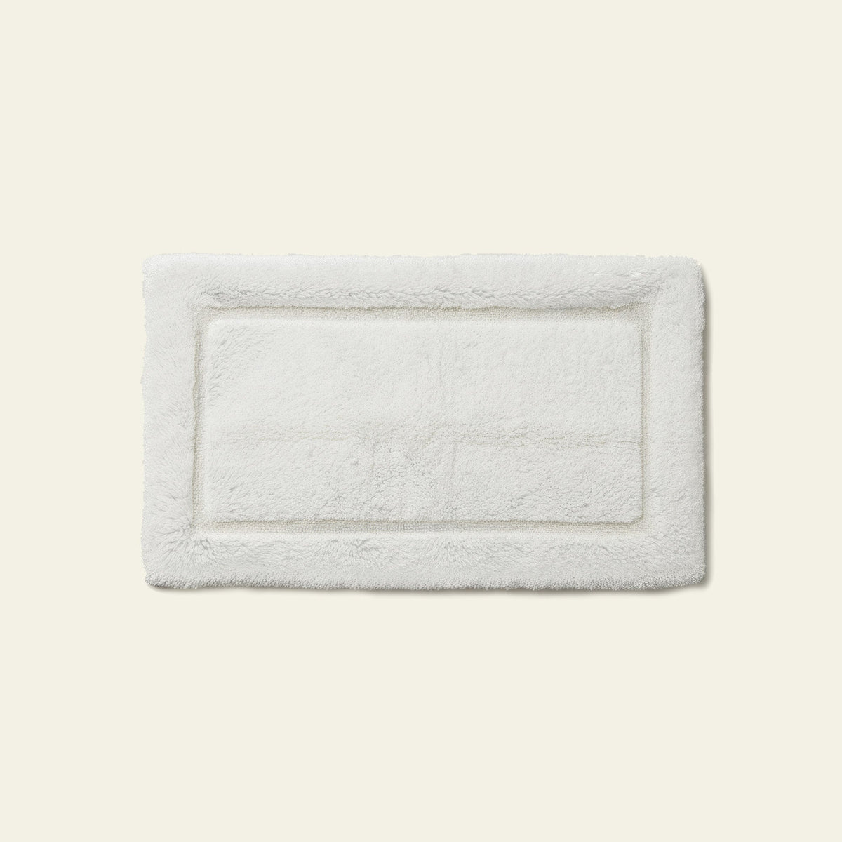 White rectangular bath mat with textured plush surface