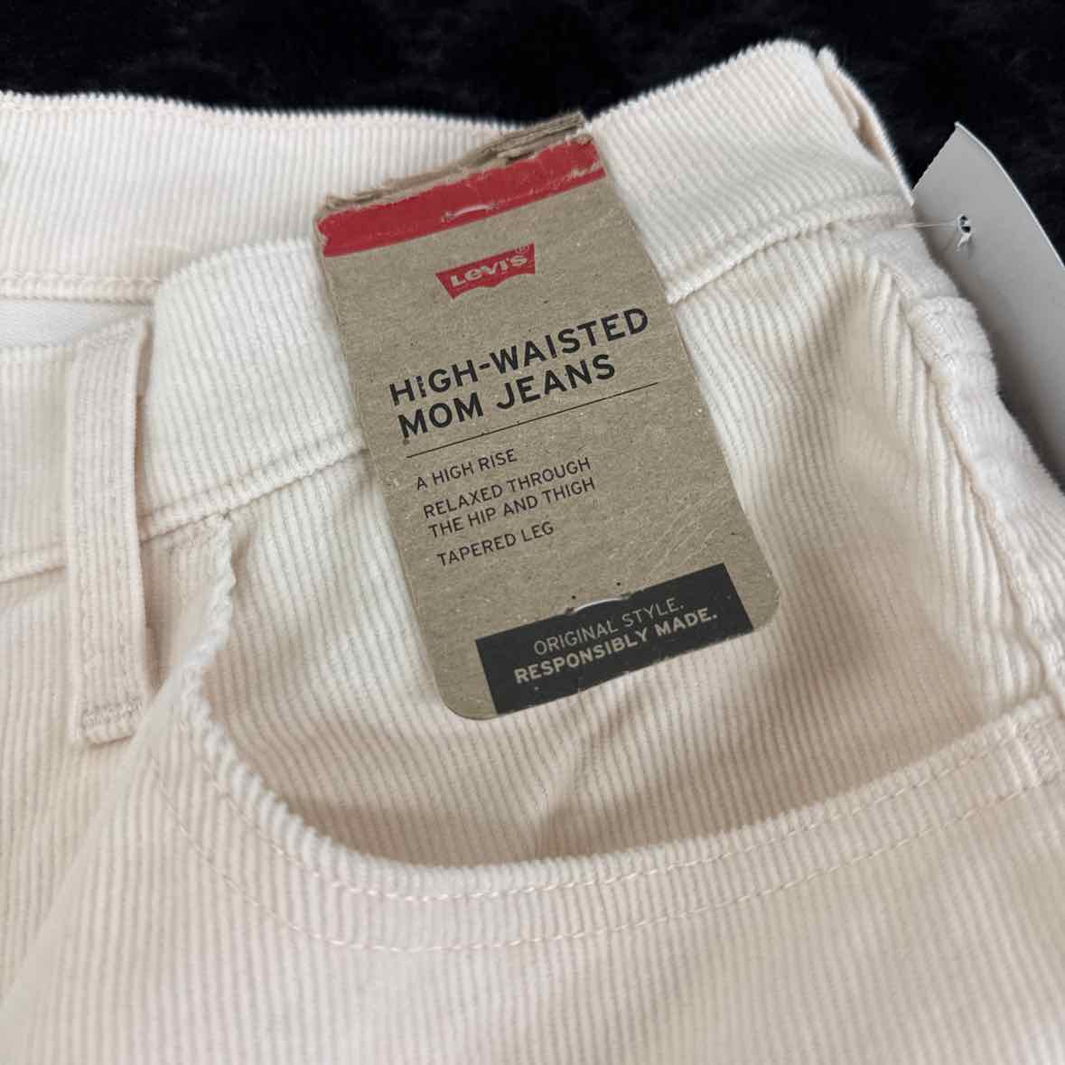 High-waisted mom jeans care label on cream corduroy waistband