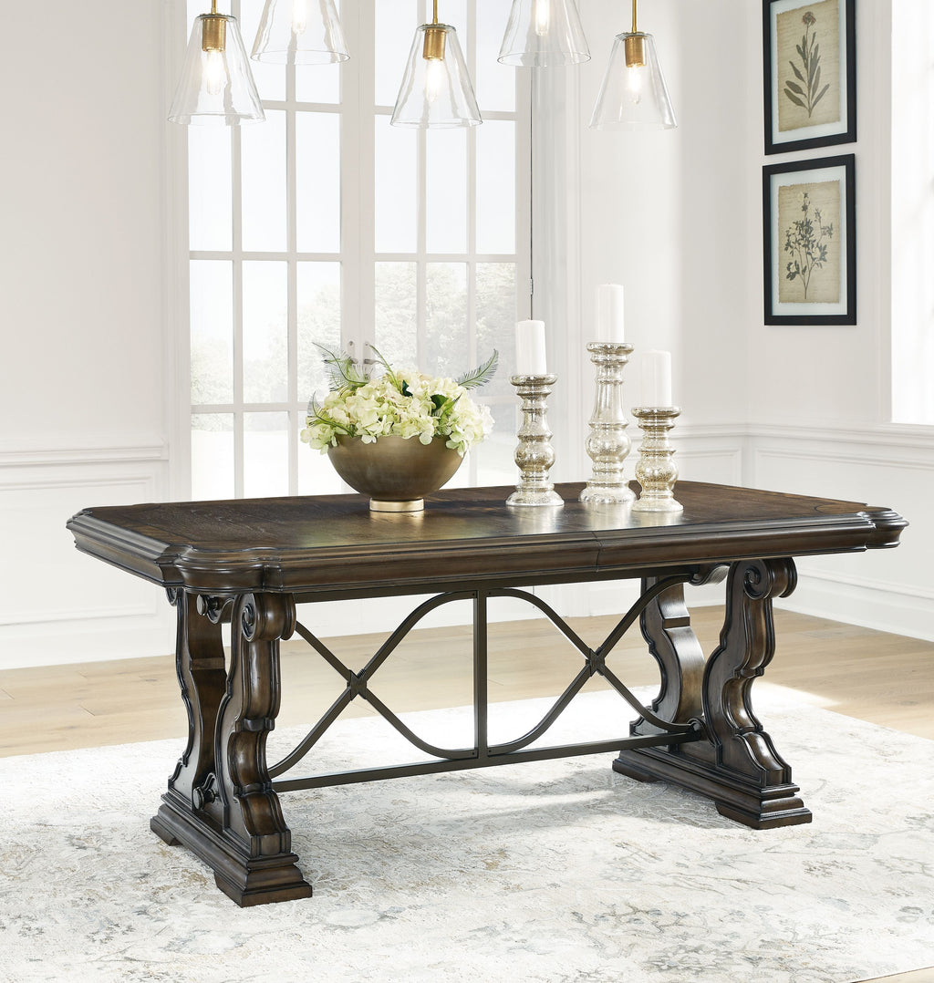 Dark brown dining extension table with X-base and decorative wood carvings