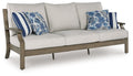 Outdoor sofa with light gray cushions and blue floral striped throw pillows