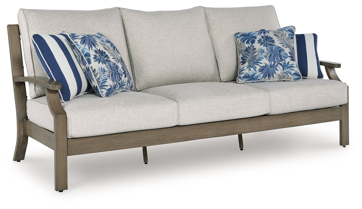 Outdoor sofa with light gray cushions and blue floral striped throw pillows