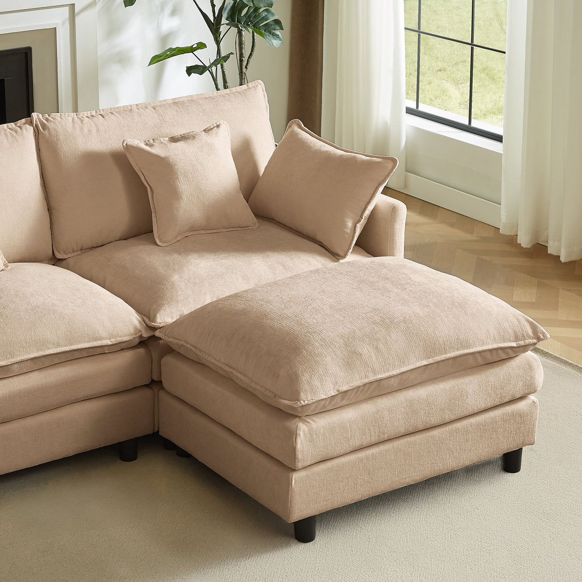 Beige chaise lounge section with two pillows, wide seat cushion, and soft fabric upholstery.