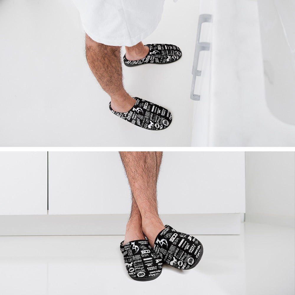 Black cotton slip-on slippers with white logo print, worn by person with shorts