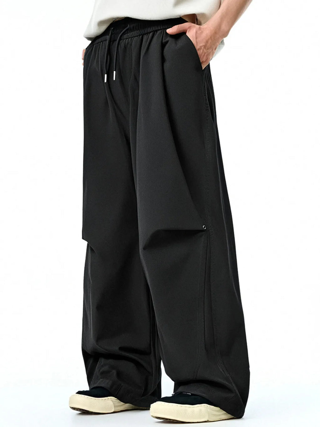 Black loose-fit casual pants with elastic waist, drawstring, and side cargo pocket.