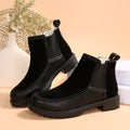 Black platform ankle boots with low heel, pull-on sides, and stitched panels