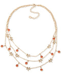 Gold-tone layered charm necklace with orange stone beads and star dangles