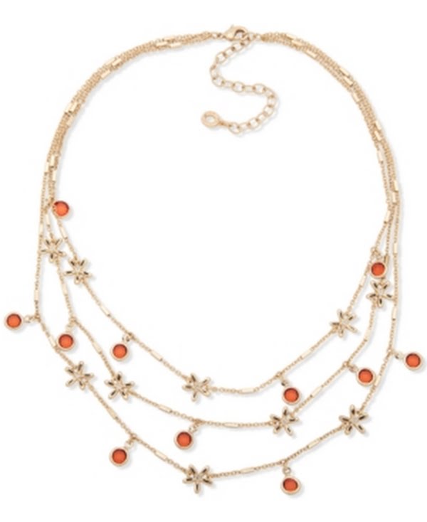 Gold-tone layered charm necklace with orange stone beads and star charms, side view