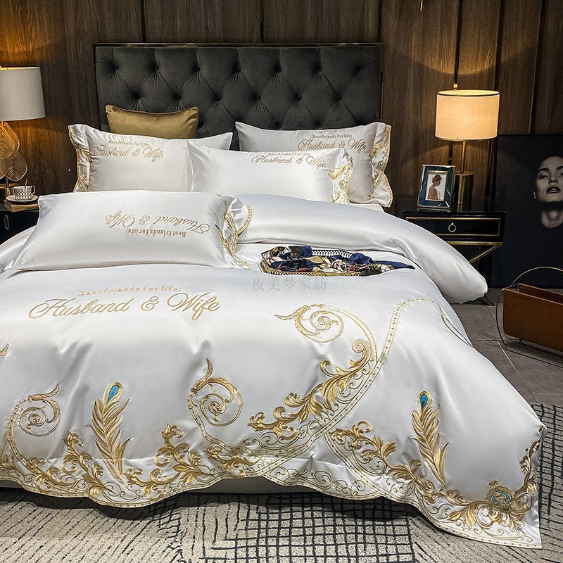 White quilted bed sheet set with gold and blue ornate embroidery and matching pillowcases